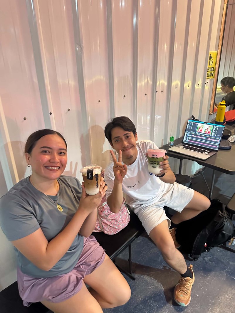 Two customers smiling with their Ruje Café drinks
